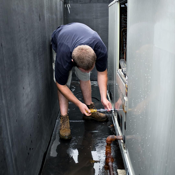 hvac tech repairing an ac unit