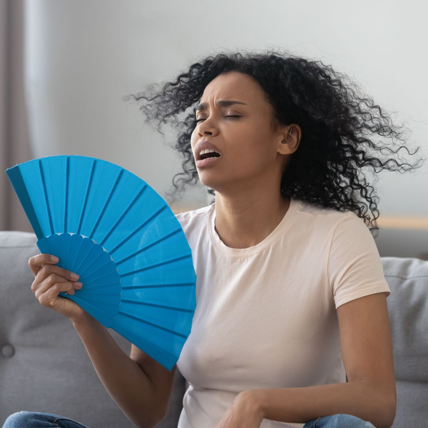 woman fanning herself at home