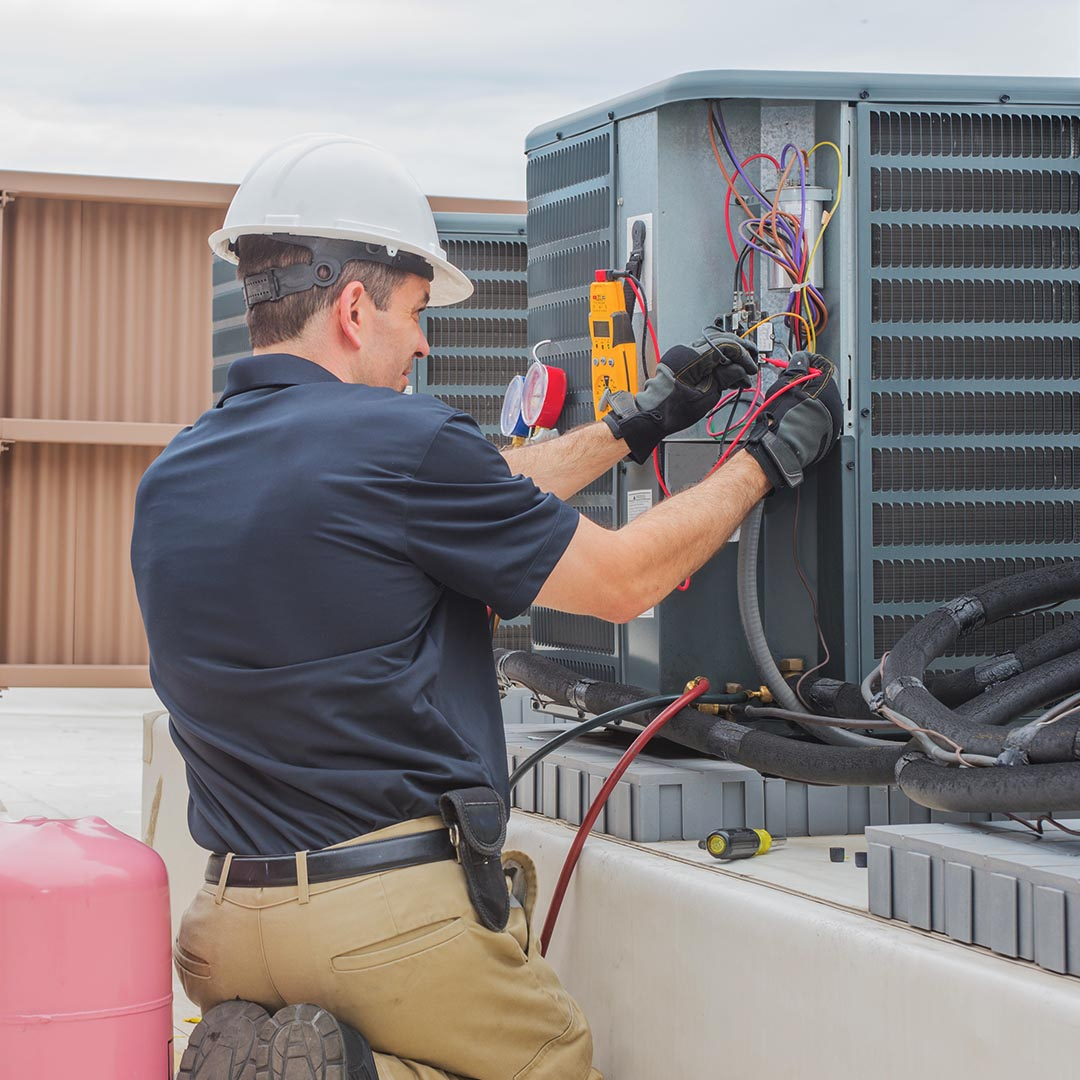 hvac tech working on a commercial ac unit hvac tech working on a commercial ac unit