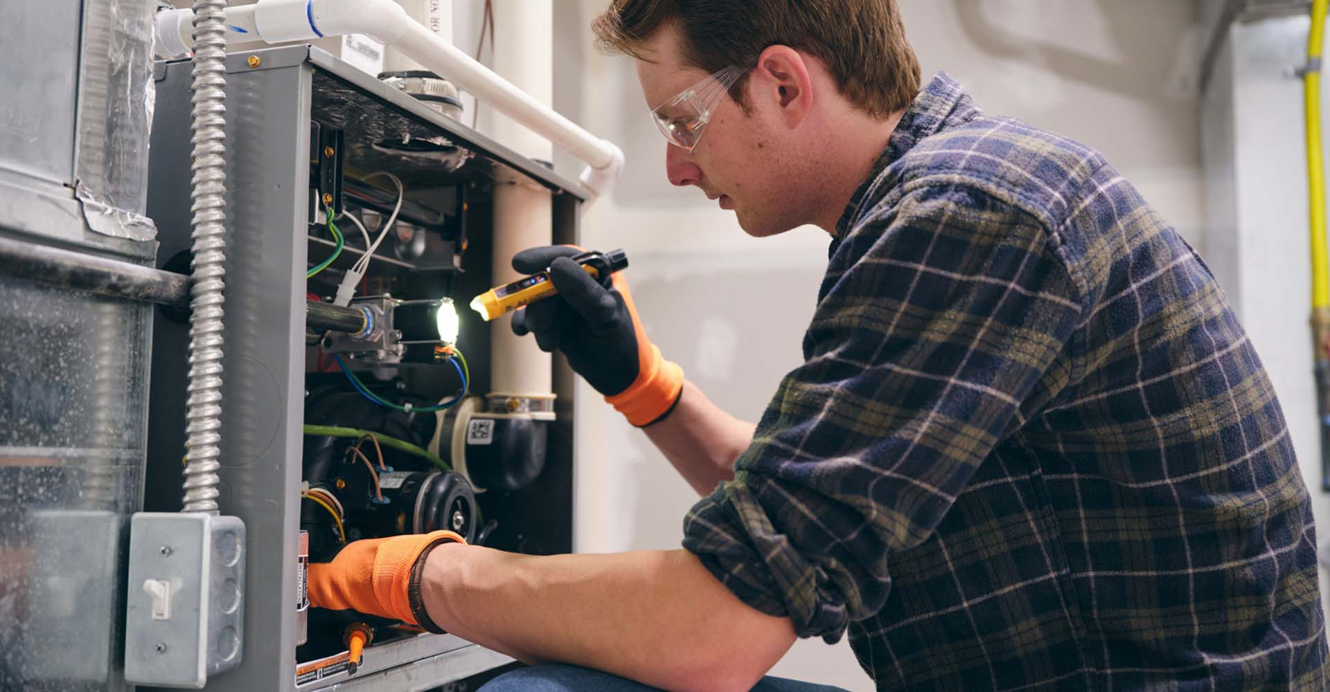 An HVAC repairman inspecting a unit