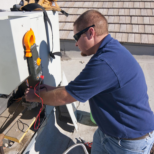 hvac tech repairing a commercial ac unit