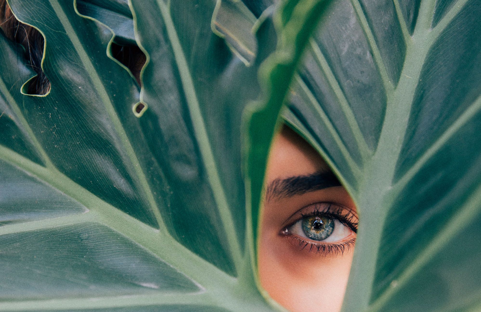 Woman peeking through leaves