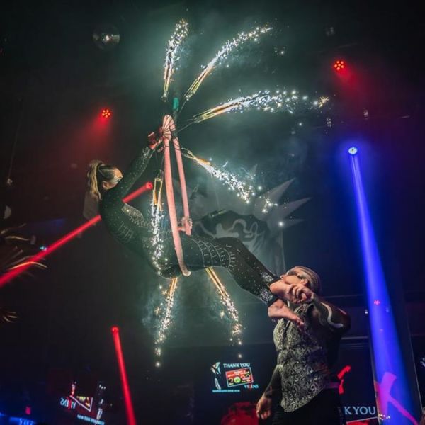 An elegant aerialist performs during a wedding reception.