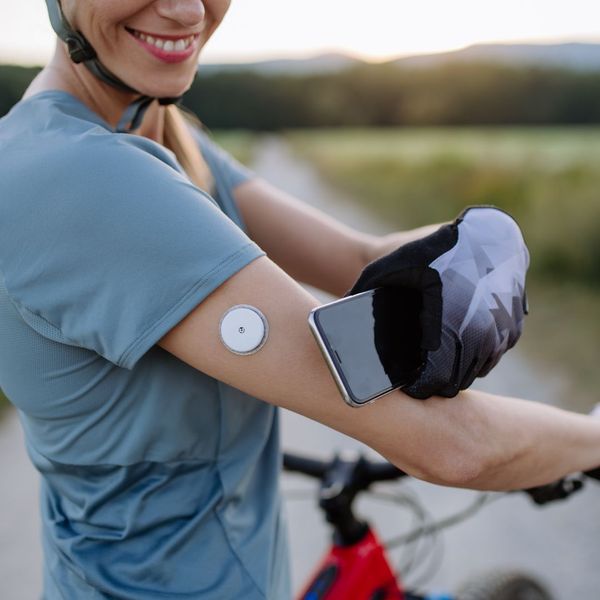 Someone on a bike showing their CGM sensor