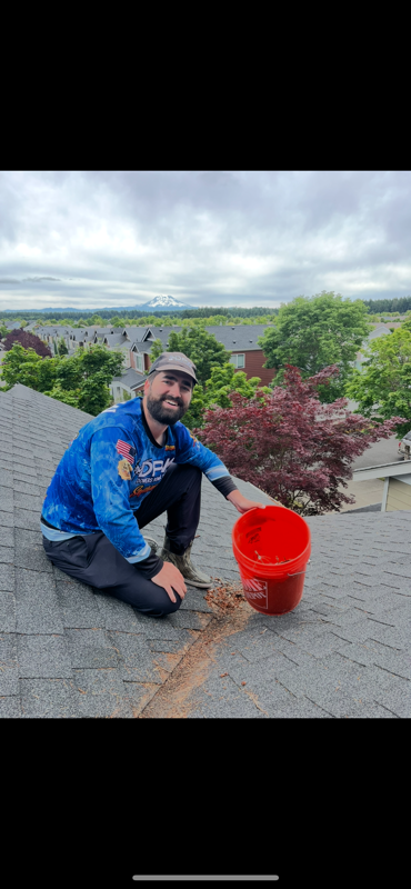 employee on roof with bucket
