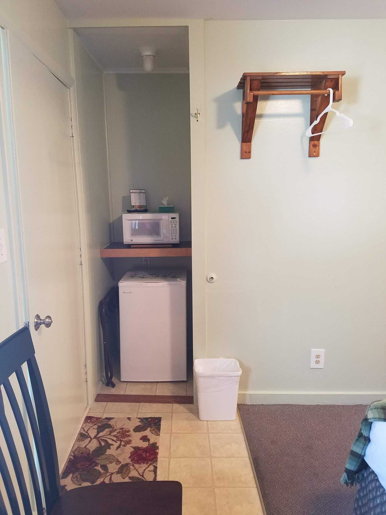 a room with a mini fridge and a microwave