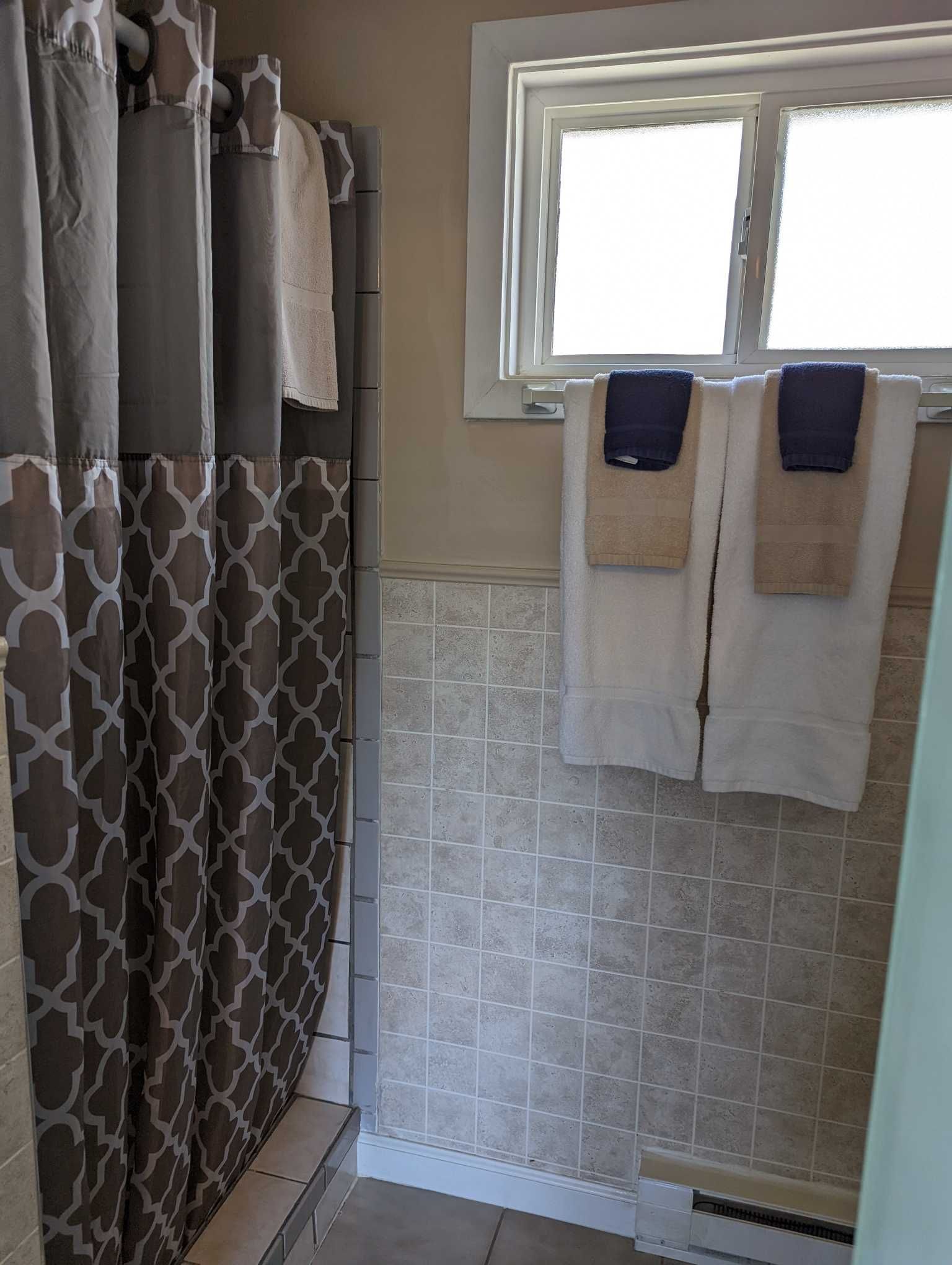 a tan bathroom with a shower stall covered by a brown bathroom curtain
