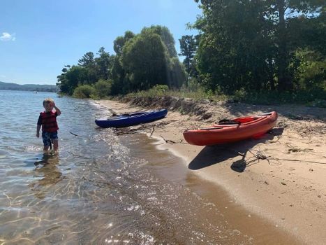 boy on beach with kayaks