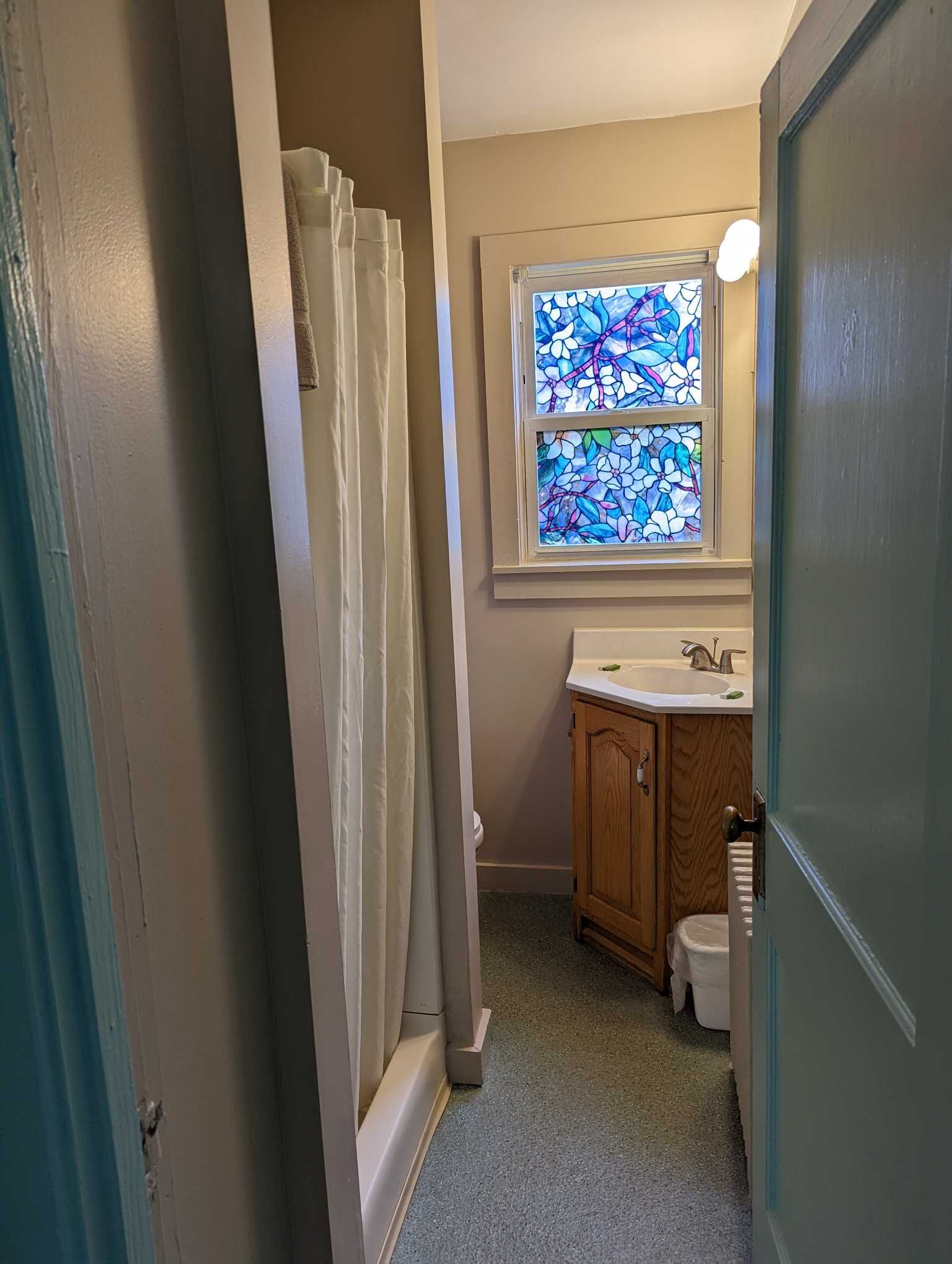 a bathroom with a corner sink and a shower stall