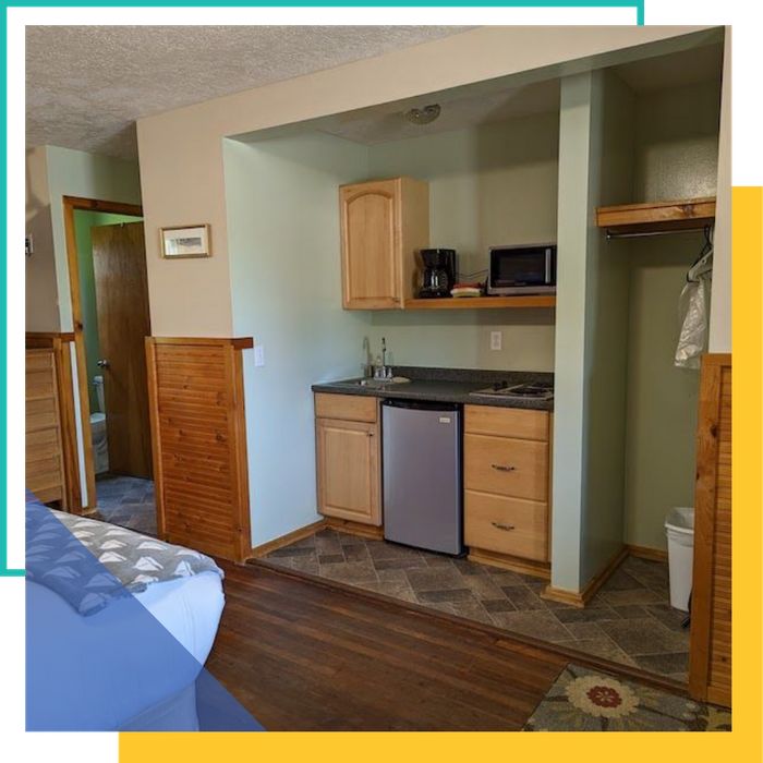 Kitchenette cabin room at Mitchel Creek Inn, featuring a mini-fridge, sink, microwave, and stovetop.