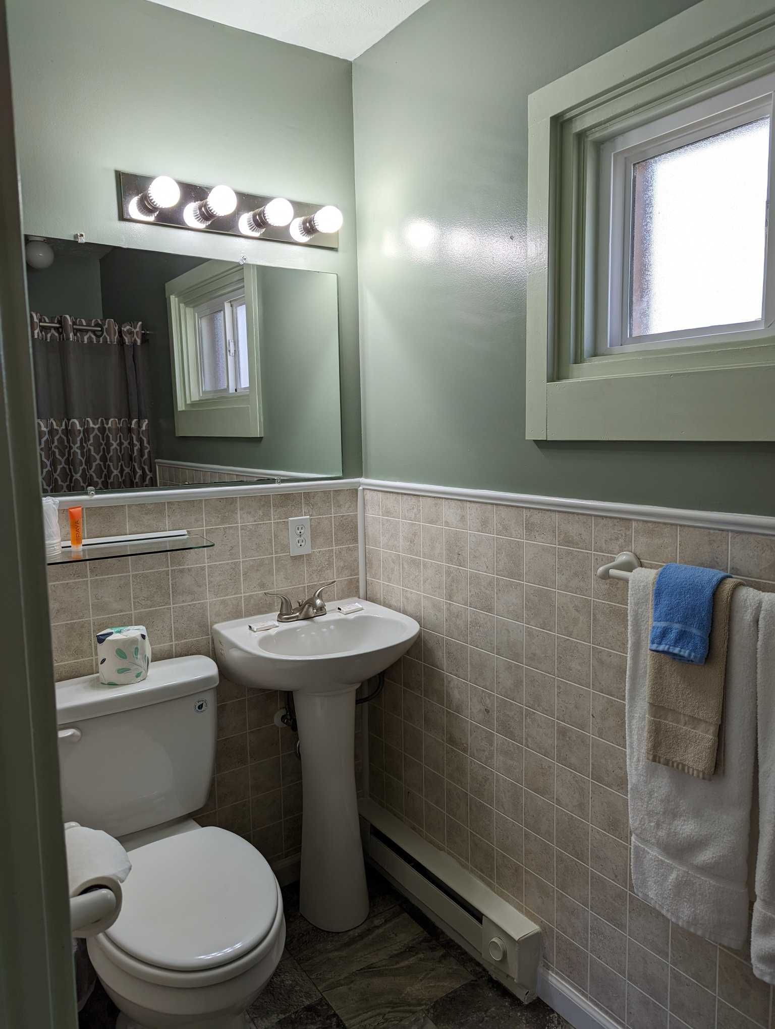 a green and tan tiled bathroom 