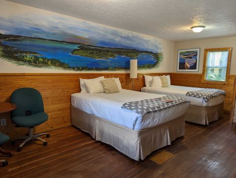 a two bed room with a sitting area and a water mural