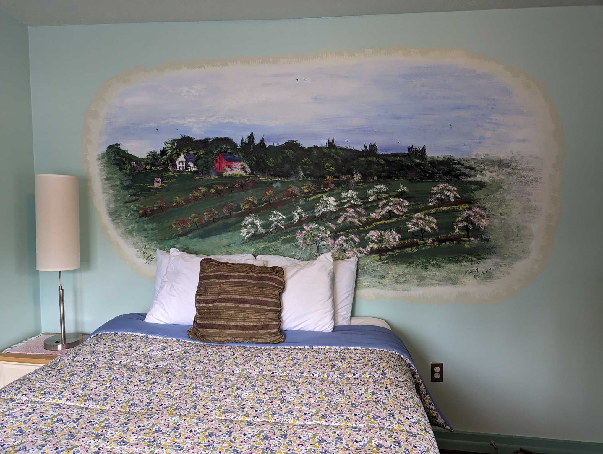 a light green room with an cherry orchard mural