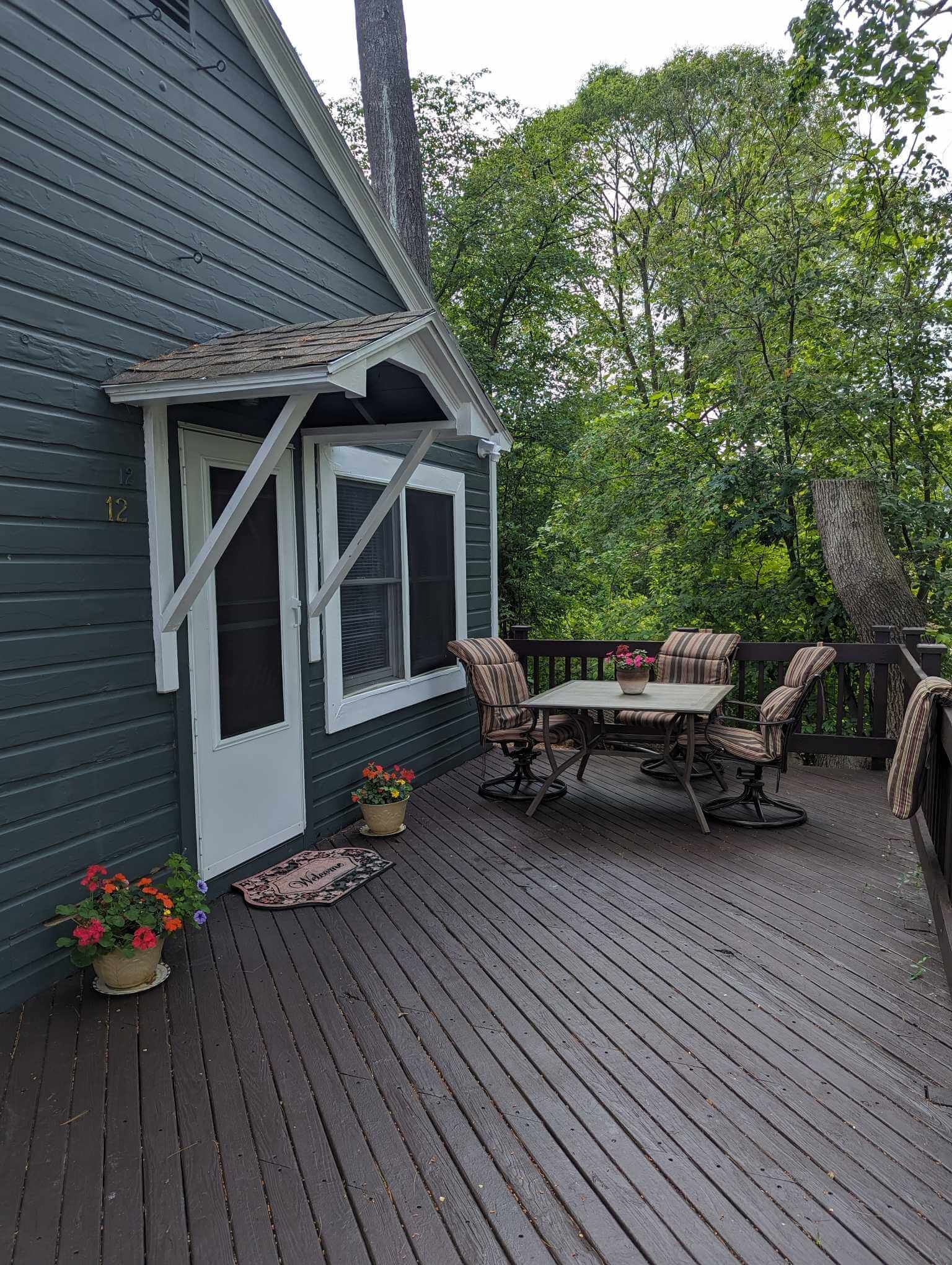 a cabin deck with an entry to the cabin and a seating area