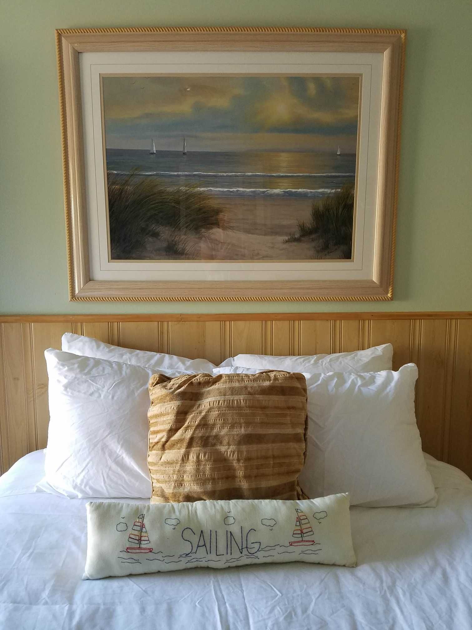 a green and wood accented room with a single bed and a beach theme