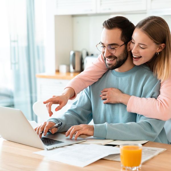 couple pointing and smiling at laptop