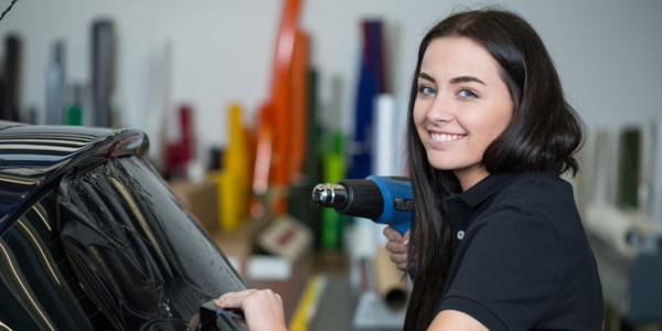 Woman tinting car window