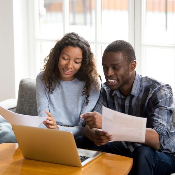 A biracial couple filling out paperwork.