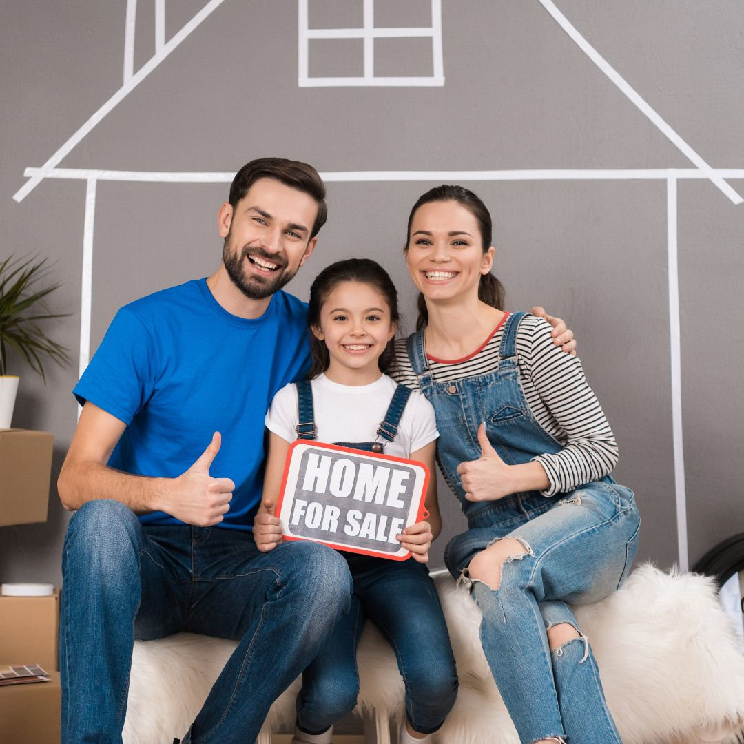family holding a home for sale sign
