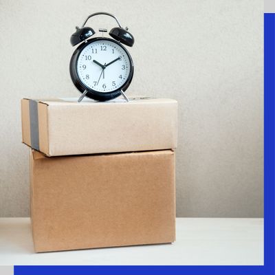 Alarm clock on top of two shipping boxes Alarm clock on top of two shipping boxes