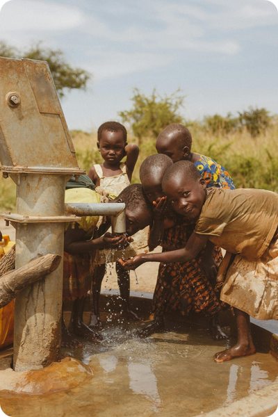 children getting water from well pump