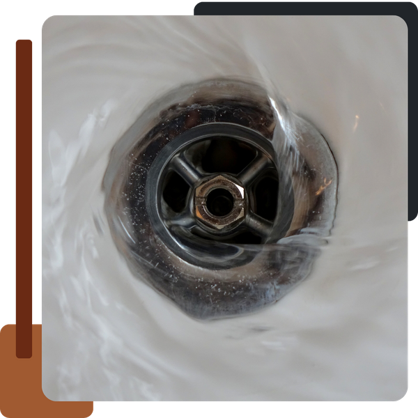 A close-up, high-angle view of water swirling down a shiny, chrome-plated drain with visible cross-hatched metal at the center.