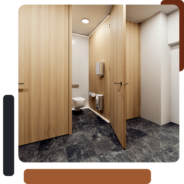 An interior view of a modern commercial restroom with dark, marbled floor tiles and light wooden partitions and doors for the stalls.