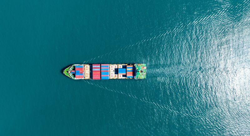 cargo ship leaving a water wake behind it