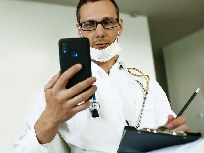Doctor looking at a cell phone