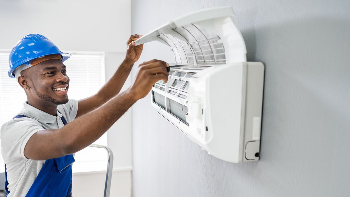 man fixes ductless AC