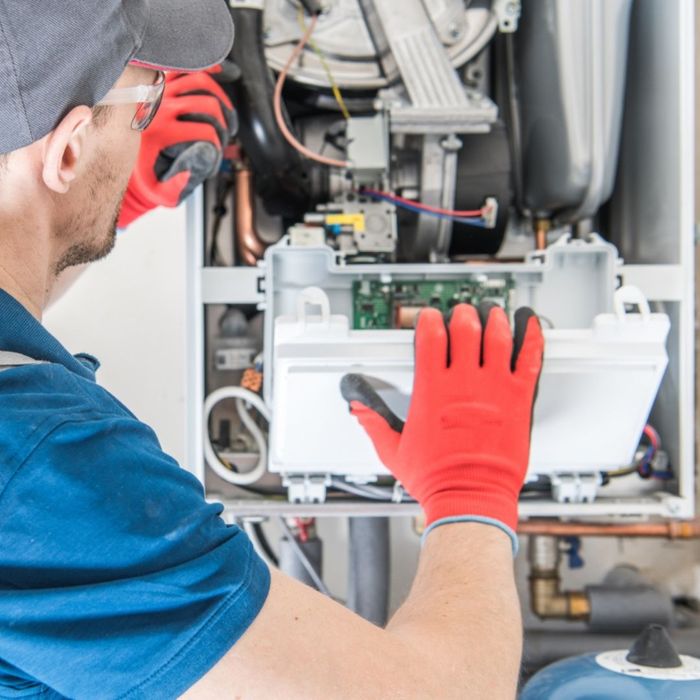 a person repairing a furnace panel