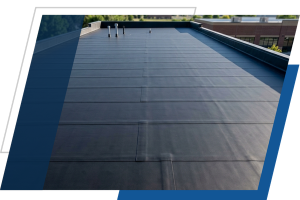 Freshly installed flat EPDM rubber roofing membrane with watertight sealed seams.