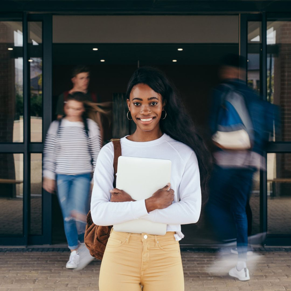 teenage student at school entrance wearing backpack