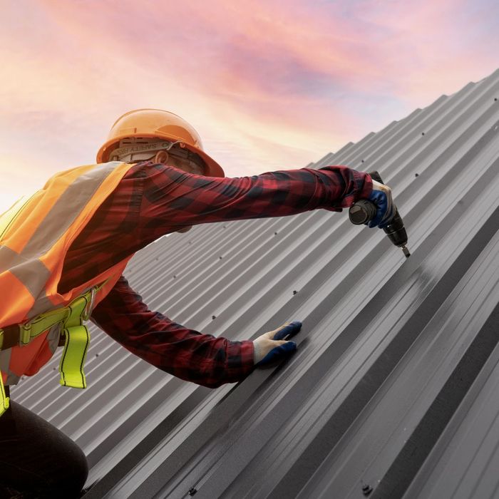 Roofer drilling into a roof.