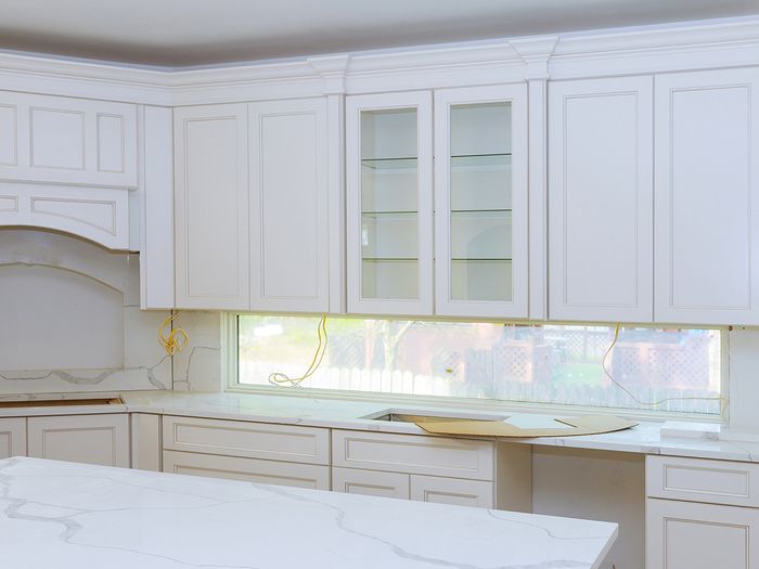An all-white kitchen with white marble countertops.