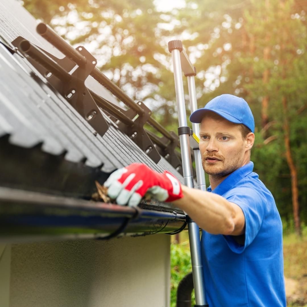 Man cleaning out eavestrough before winter