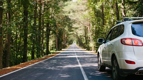 car with tinted windows driving along road