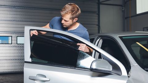 window tinting technician placing tint on car window