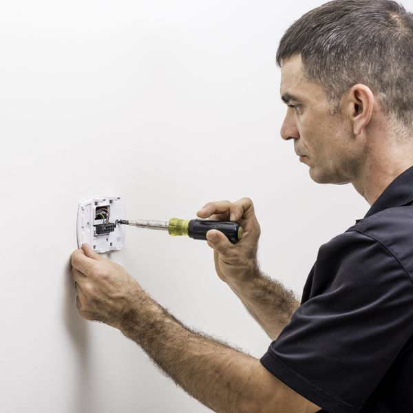 Man working with a thermostat