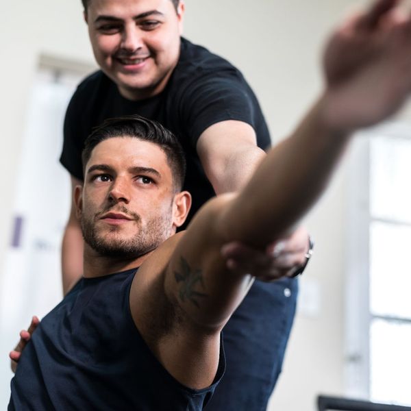 physical therapist stretching man's arm