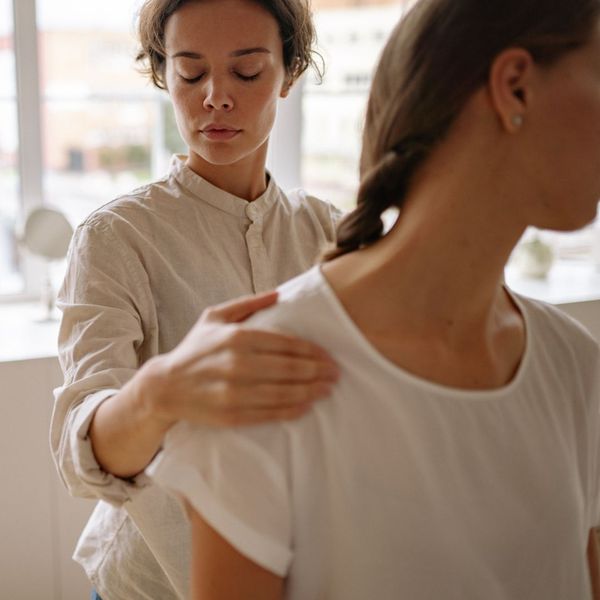 woman stretching neck and shoulder with physical therapist woman stretching neck and shoulder with physical therapist
