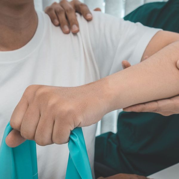 person raising their arm with physical therapist person raising their arm with physical therapist