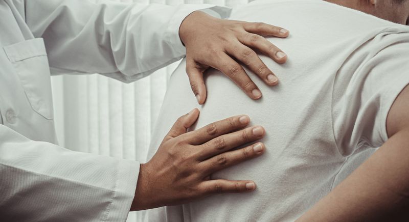 physical therapist examining back