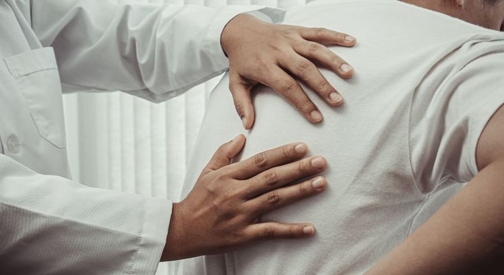 physical therapist examining back