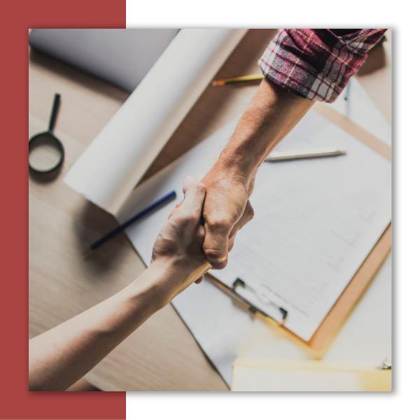 An HVAC technician shaking hands with a homeowner.