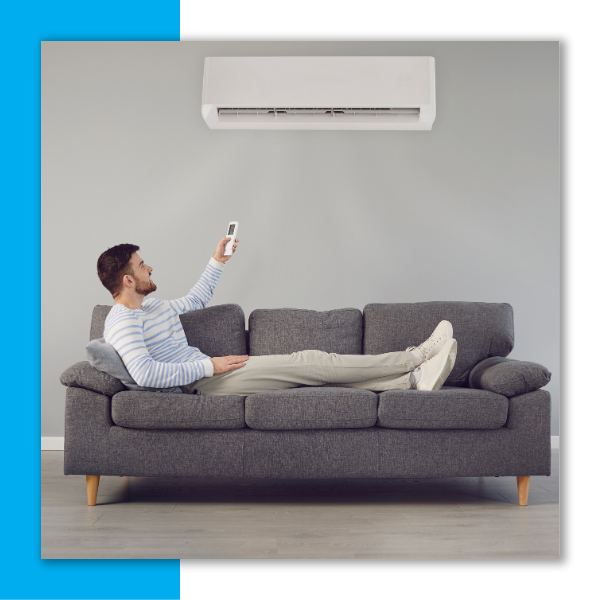 Person using a remote to control their wall-mounted AC unit in their living room.