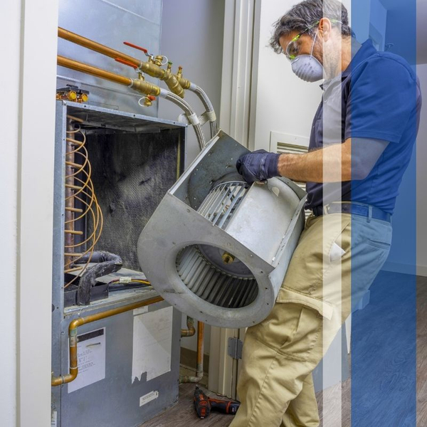 Technician removing a blower wheel from an air handler unit Technician removing a blower wheel from an air handler unit