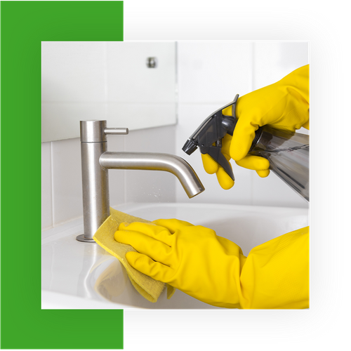 Person cleaning a sink with towel and spray