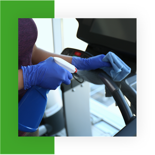 Woman disinfecting a treadmill