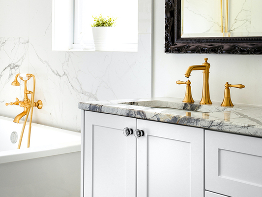 Close up of a sink with granite a countertop and gold trim